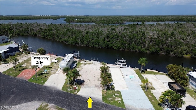 drone / aerial view with a forest view and a water view