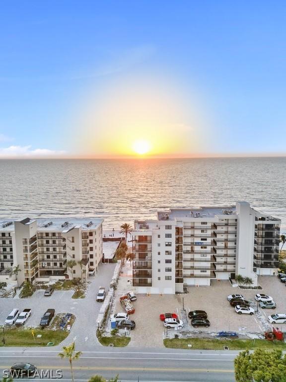 aerial view at dusk featuring a water view