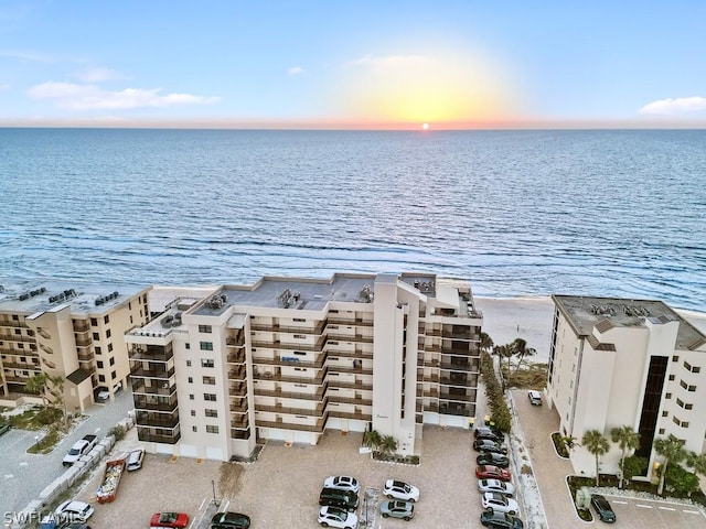 aerial view at dusk featuring a water view