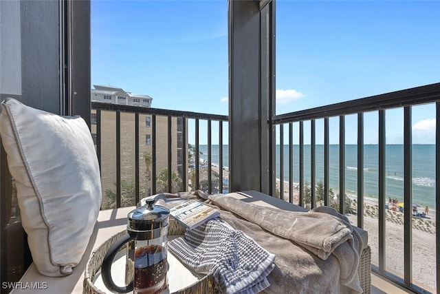 balcony featuring a water view and a view of the beach