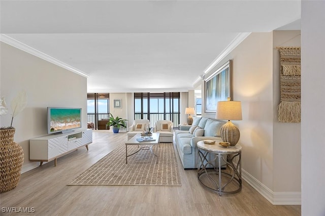 living room with ornamental molding, a wealth of natural light, and light hardwood / wood-style flooring