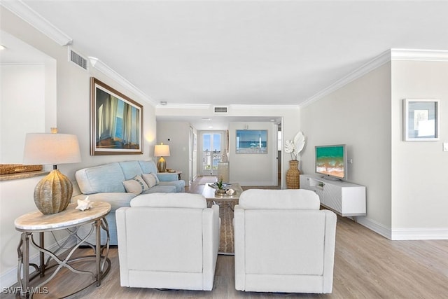 living room with ornamental molding and light hardwood / wood-style flooring