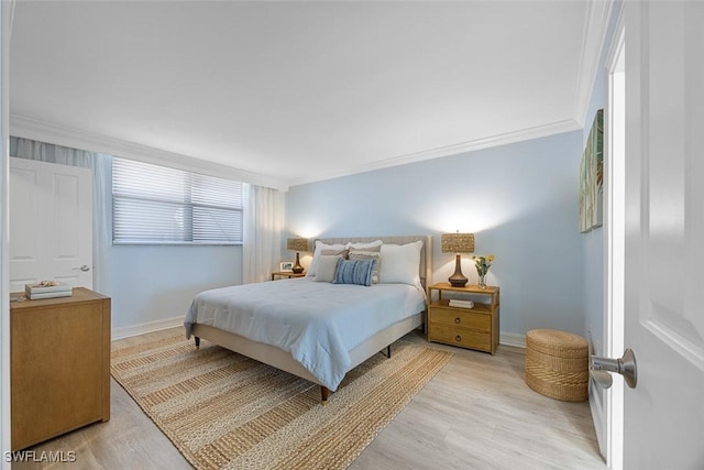 bedroom featuring light wood-type flooring and crown molding