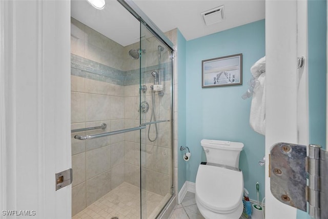 bathroom with tile patterned flooring, toilet, and walk in shower