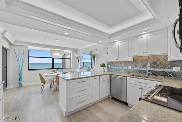 kitchen with dishwasher, decorative light fixtures, kitchen peninsula, white cabinets, and ornamental molding