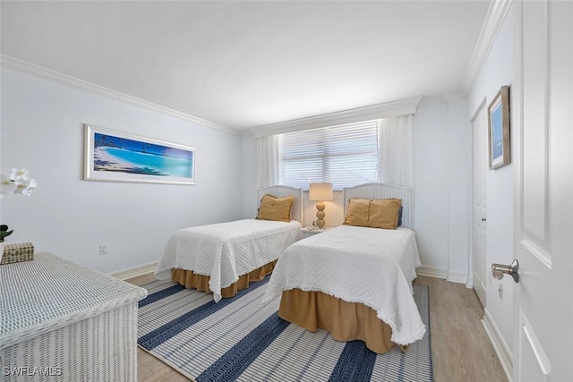 bedroom with ornamental molding and light hardwood / wood-style flooring