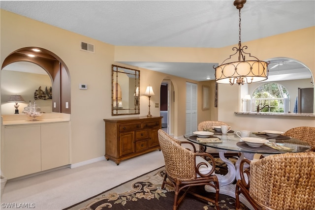 carpeted dining room featuring a textured ceiling