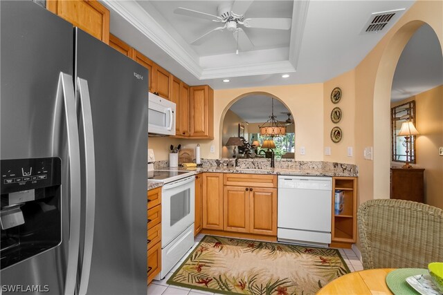 kitchen featuring ceiling fan, sink, white appliances, a tray ceiling, and light tile patterned flooring