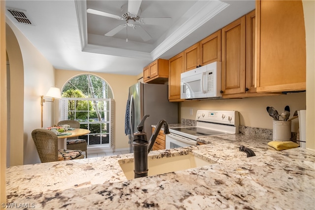 kitchen with white appliances, a tray ceiling, ceiling fan, and sink