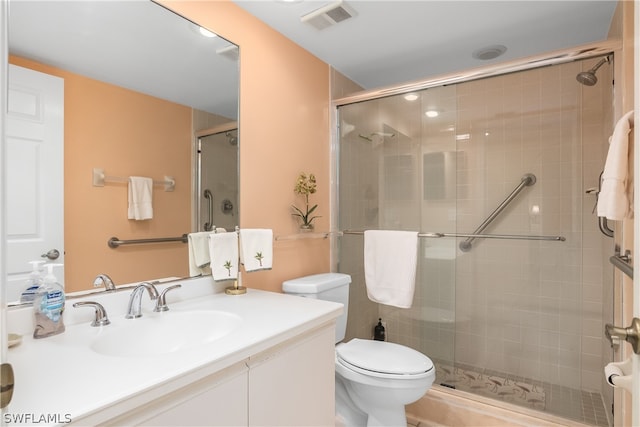 bathroom featuring vanity, an enclosed shower, and toilet