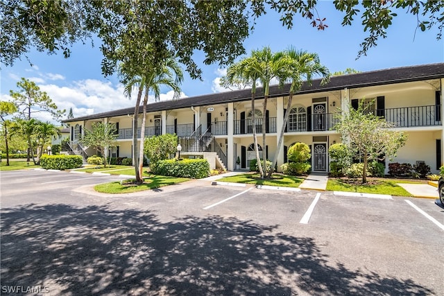 256 Deerwood Cir Unit 4, Naples, FL 34113 - view of building exterior featuring stairs and uncovered parking