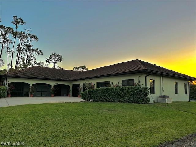 ranch-style home featuring a yard and a garage