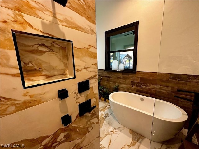 bathroom with a washtub and tile walls