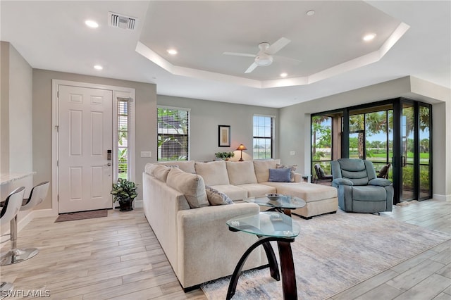 living room featuring light hardwood / wood-style floors, ceiling fan, and a healthy amount of sunlight