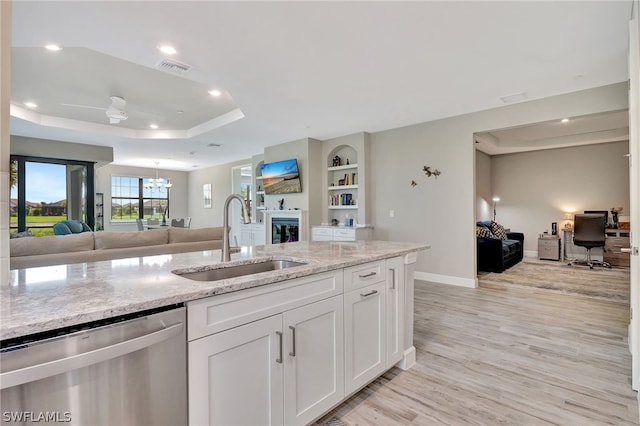 kitchen featuring white cabinetry, stainless steel dishwasher, light hardwood / wood-style floors, and sink