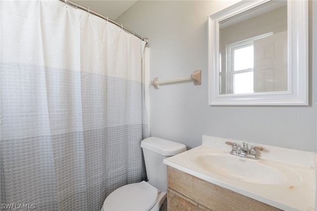 bathroom featuring a shower with curtain, vanity, and toilet