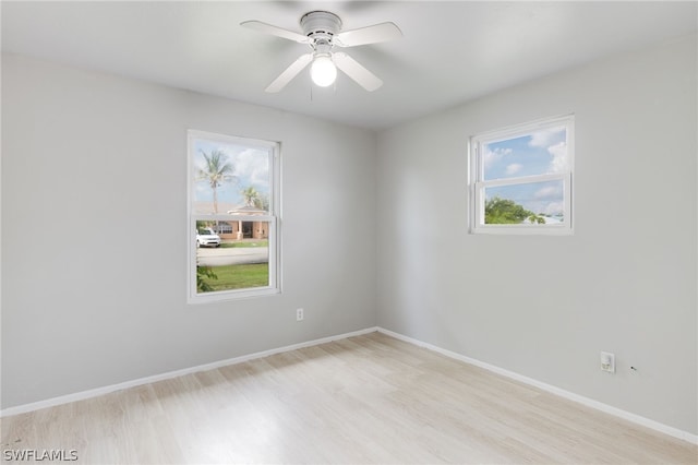 empty room featuring ceiling fan, plenty of natural light, and light wood-type flooring