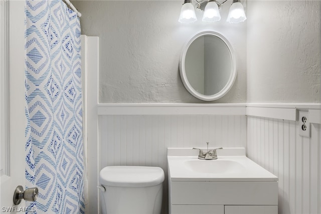 bathroom featuring vanity, toilet, and curtained shower