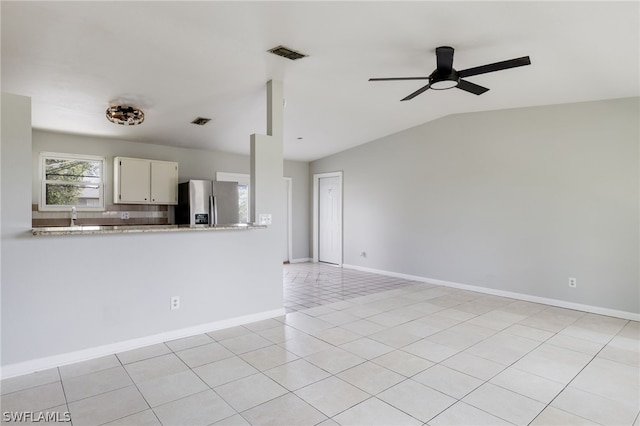 interior space with lofted ceiling, ceiling fan, light tile patterned floors, and sink