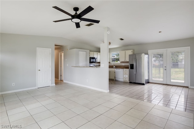 kitchen featuring ceiling fan, dishwasher, stainless steel fridge, lofted ceiling, and light tile patterned floors