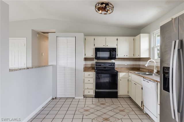 kitchen with cream cabinets, black appliances, sink, vaulted ceiling, and light tile patterned floors