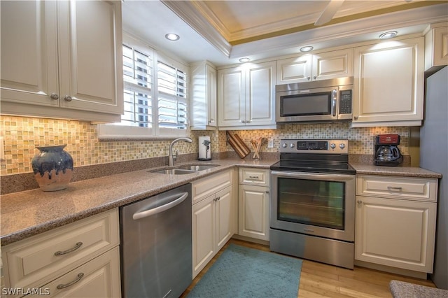 kitchen featuring stainless steel appliances, tasteful backsplash, crown molding, and sink