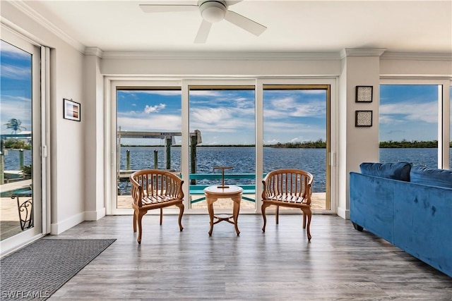 sunroom featuring ceiling fan, plenty of natural light, and a water view