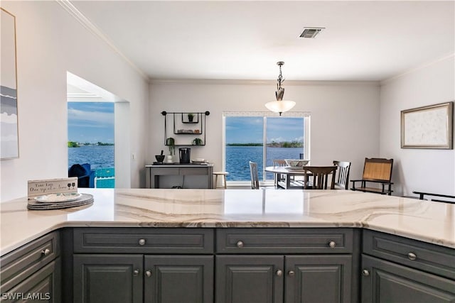 kitchen with a water view, crown molding, and pendant lighting