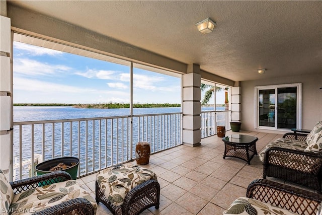 sunroom / solarium featuring a water view