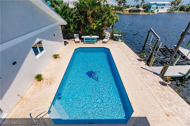 view of pool with a water view and a patio area