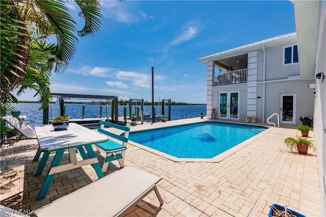 view of swimming pool featuring a water view and a patio