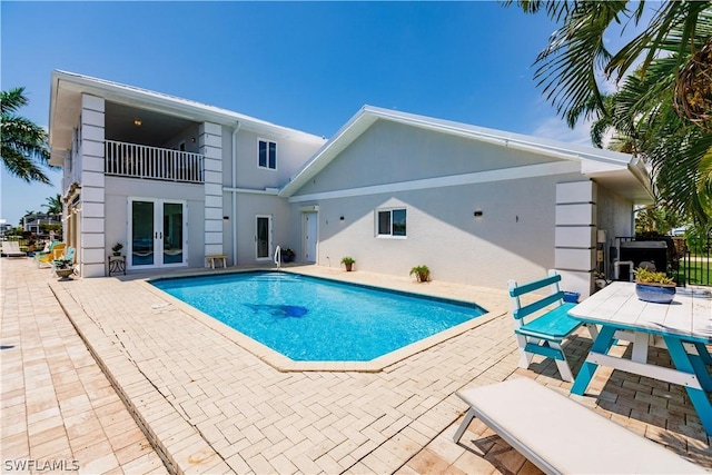 view of swimming pool featuring french doors and a patio area