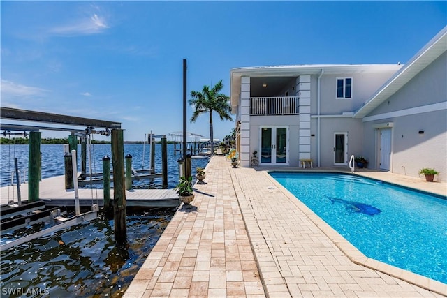 view of pool featuring a water view, french doors, and a dock