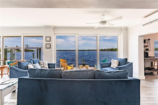 living room featuring hardwood / wood-style floors, a wall unit AC, a water view, ceiling fan, and crown molding