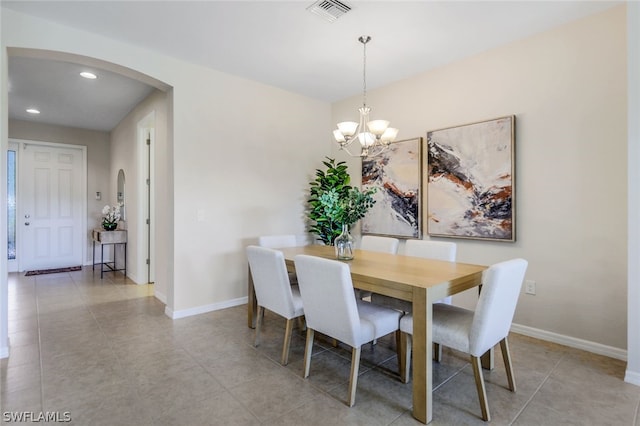 tiled dining space with a notable chandelier