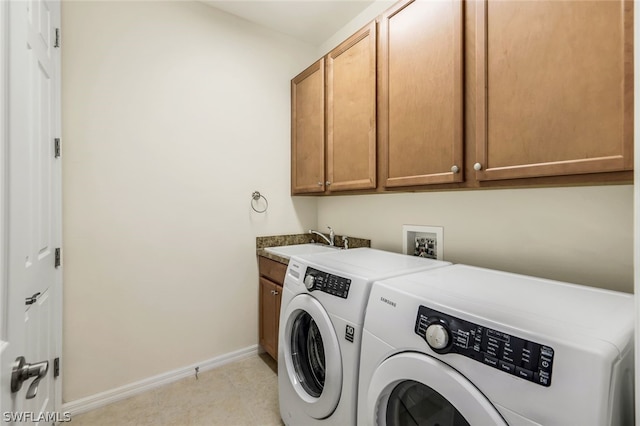 laundry room with washer and dryer, cabinets, and sink