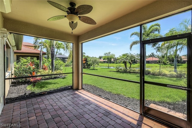 unfurnished sunroom featuring ceiling fan