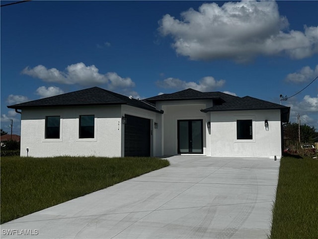 prairie-style house featuring a garage and a front yard