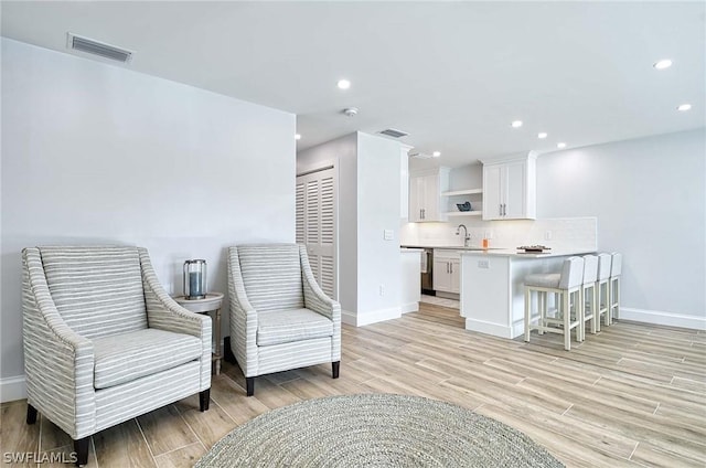 living area featuring light wood-type flooring and sink