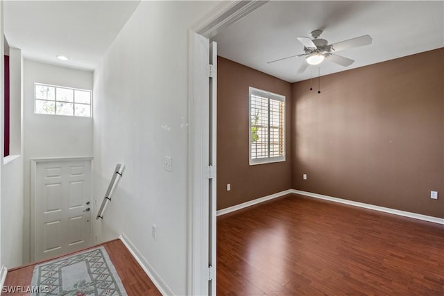 hall with plenty of natural light and dark hardwood / wood-style floors