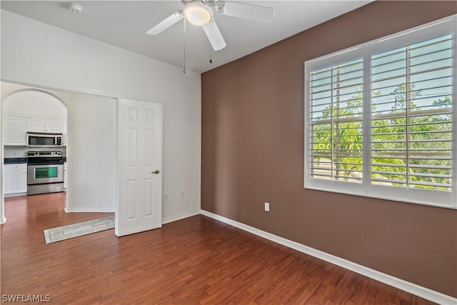 spare room featuring dark wood-type flooring and ceiling fan