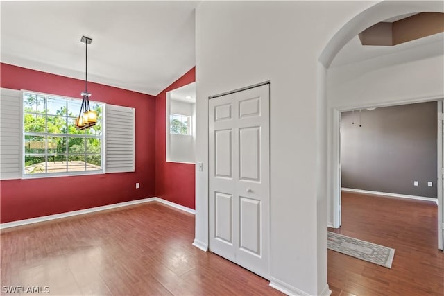 interior space with hardwood / wood-style floors, high vaulted ceiling, and a chandelier