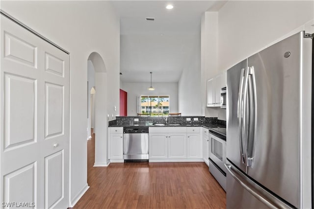 kitchen with white cabinetry, sink, kitchen peninsula, stainless steel appliances, and dark wood-type flooring