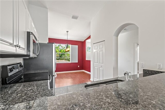 kitchen featuring sink, hanging light fixtures, dark stone countertops, stainless steel appliances, and white cabinets