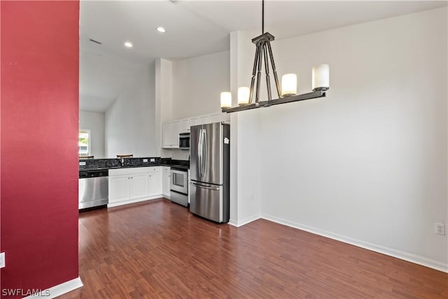 kitchen featuring appliances with stainless steel finishes, an inviting chandelier, hanging light fixtures, dark hardwood / wood-style floors, and white cabinets