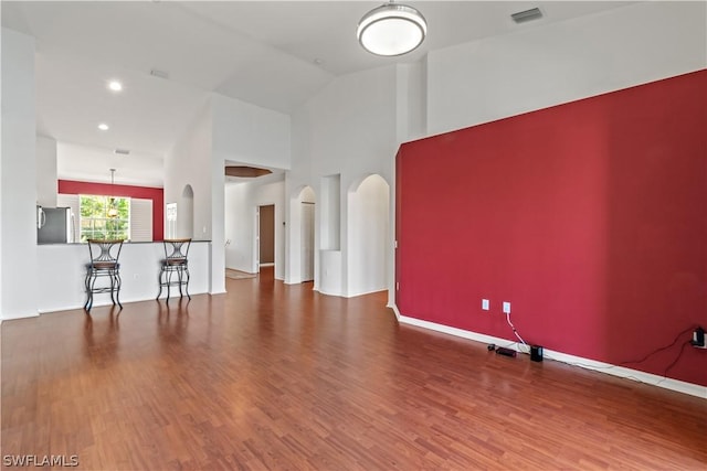 unfurnished room featuring hardwood / wood-style floors and high vaulted ceiling