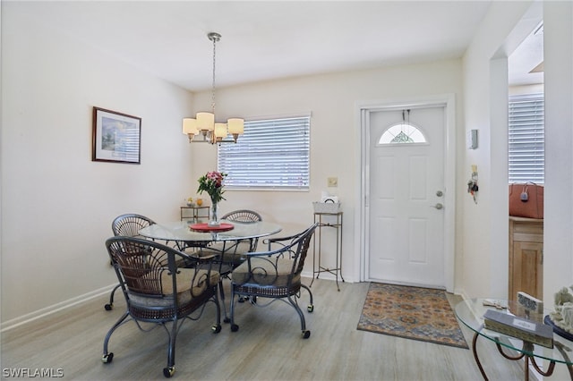 dining space featuring light hardwood / wood-style floors and a notable chandelier