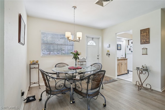 dining area with a chandelier and light hardwood / wood-style floors