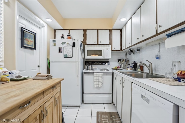 kitchen featuring white appliances, white cabinetry, tasteful backsplash, sink, and light tile patterned floors