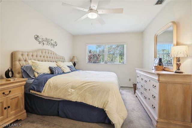 bedroom with ceiling fan, light carpet, and multiple windows